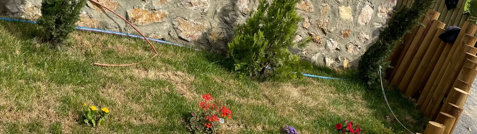 Çim, mevsimlik çiçek ve ahşap palisat bordürle düzenlenmiş bahçe